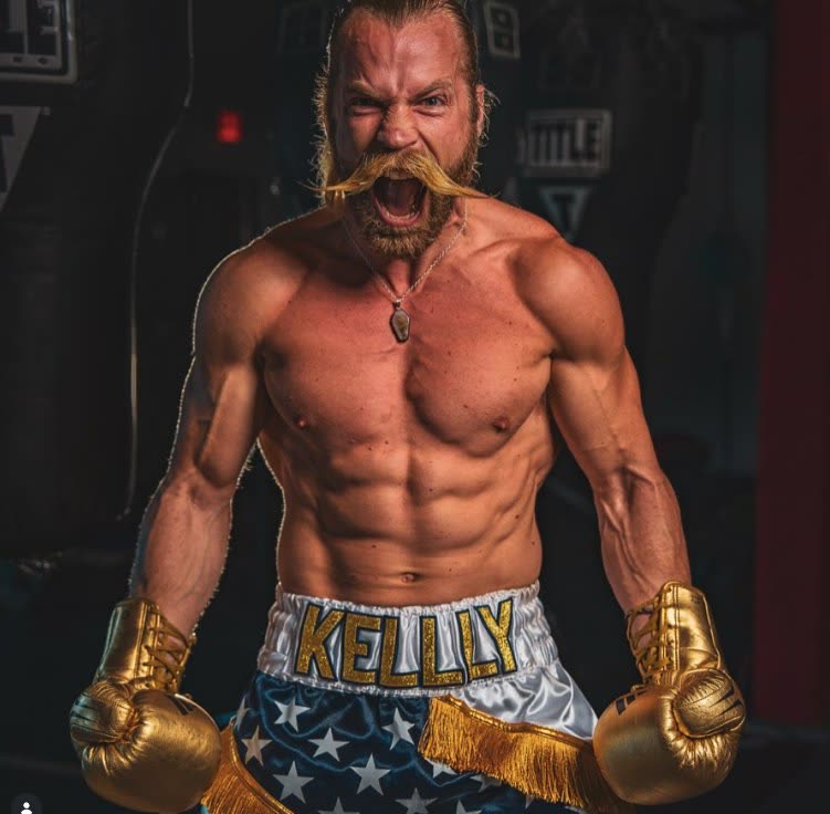 Brendan Kelly in 'KELLY' fight trunks roaring with gold boxing gloves raised — fight night intensity
